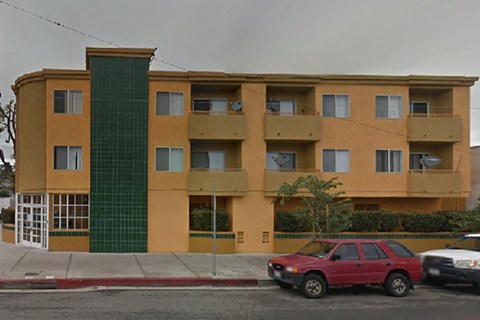 a red car parked in front of an apartment building