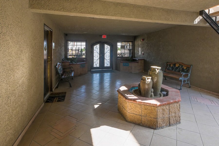 the lobby of an apartment building with a reception area and a fountain