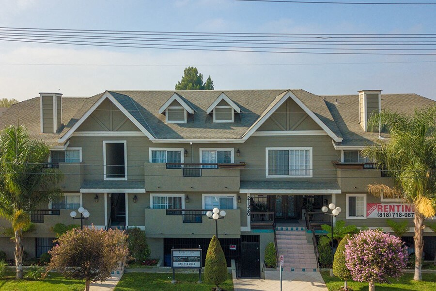 a large apartment building with a porch and a street sign