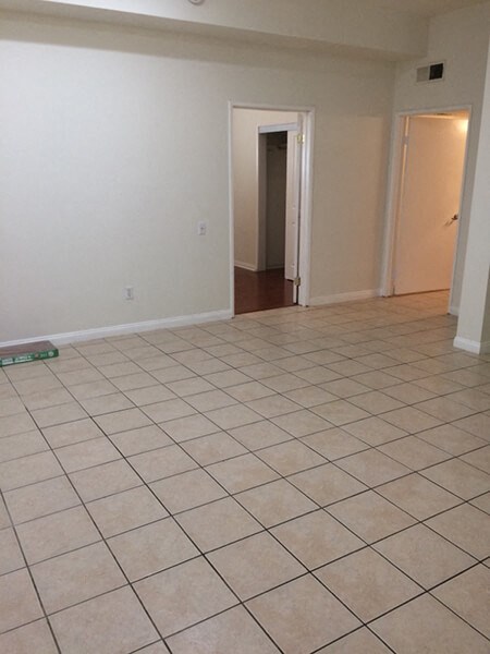 an empty living room with a tiled floor