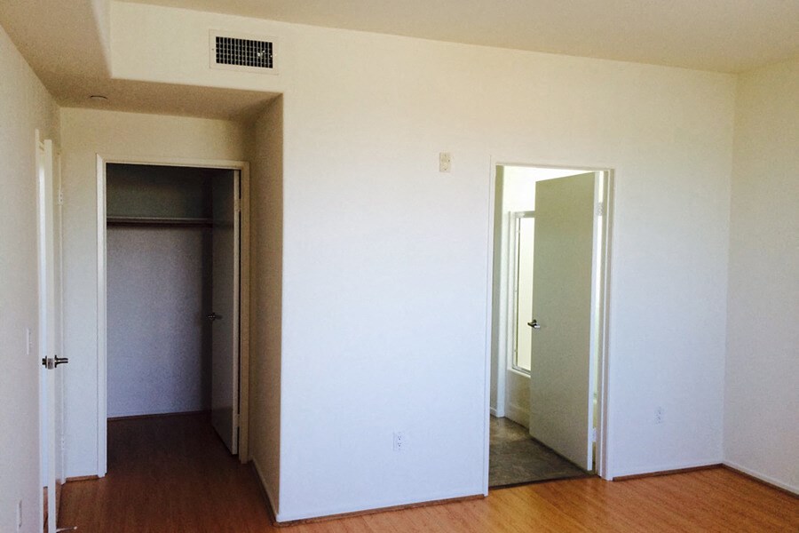 an empty living room with a door to a closet