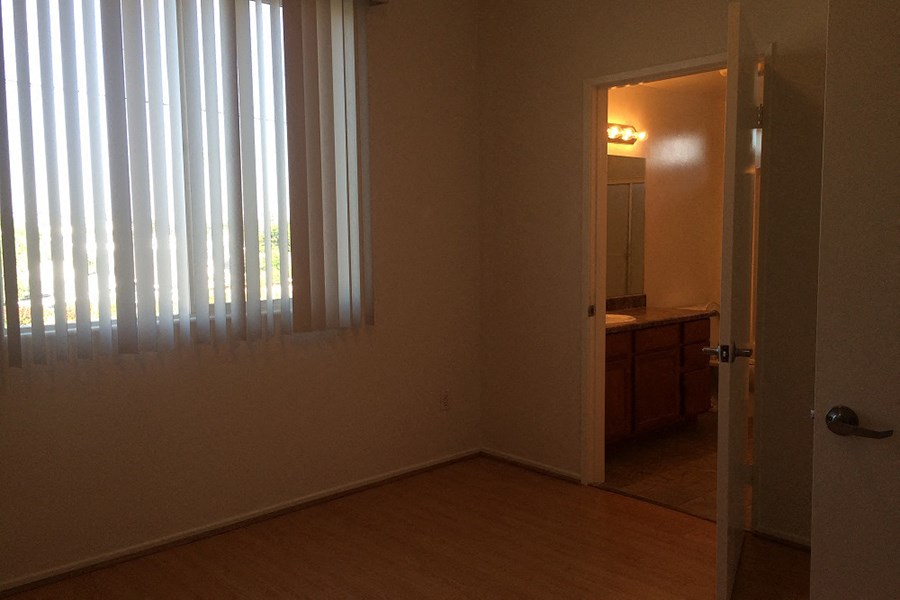 a bedroom with a door to a bathroom and a window