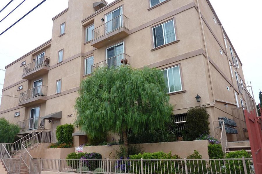 an apartment building with a tree in front of it