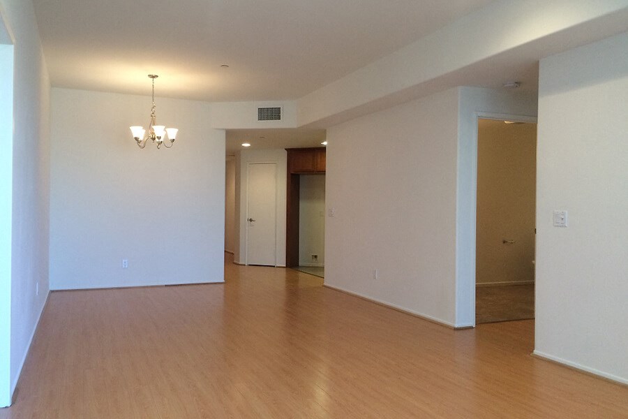 an empty living room with wood floors and white walls