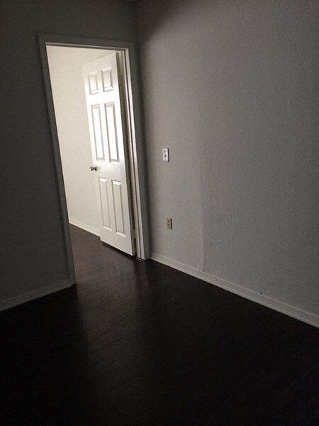 a door is open to a room with a wooden floor