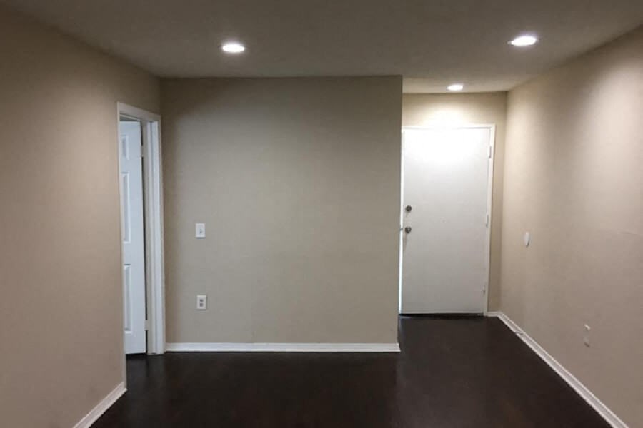 an empty living room with white walls and a wooden floor