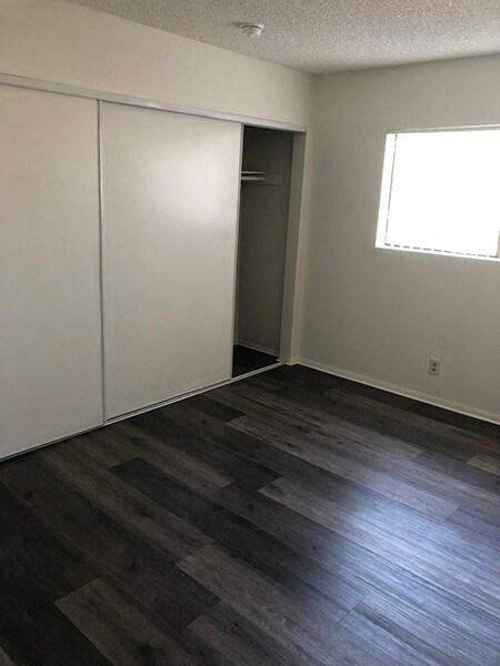 an empty room with wooden floors and a closet