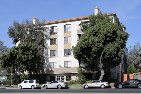 an apartment building with cars parked in front of it