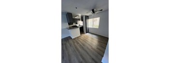 A room with a ceiling fan and wooden flooring.