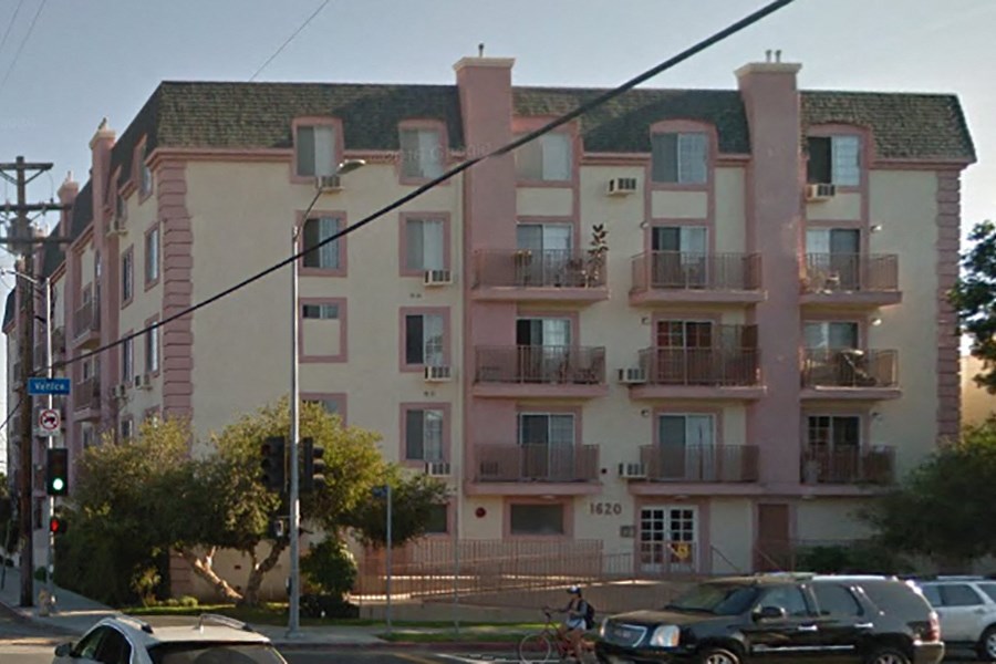 an apartment building with cars parked in front of it