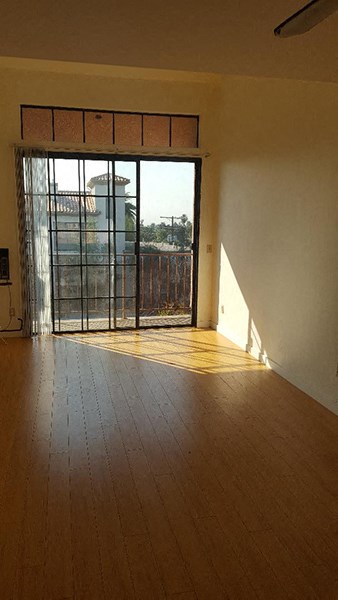 an empty living room with a wood floor and a glass door