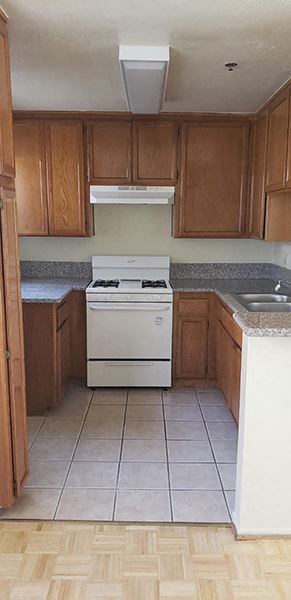 an empty kitchen with a stove and a sink