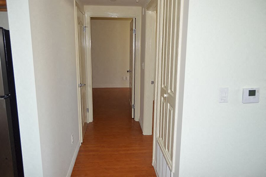 a hallway with a wood floor and white doors