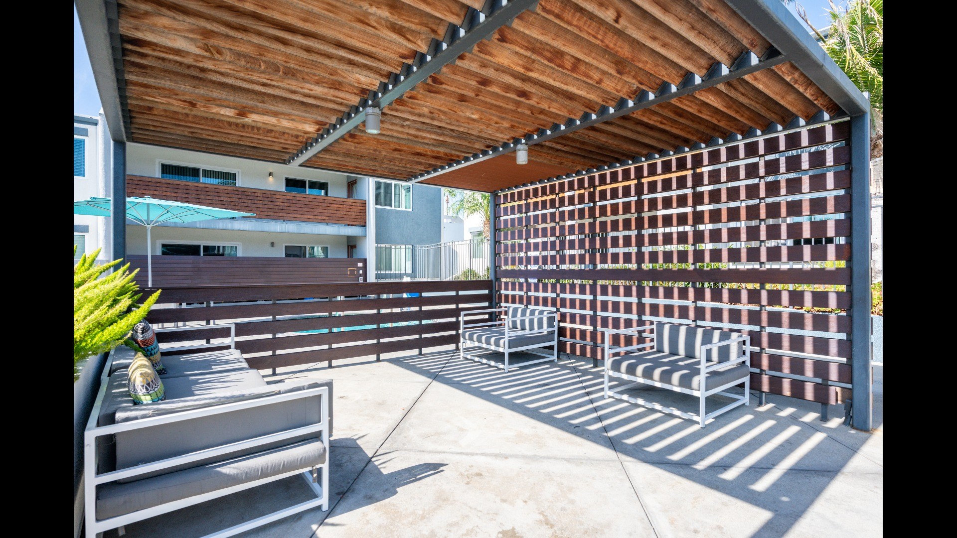 A patio with a wooden ceiling and a metal bench.