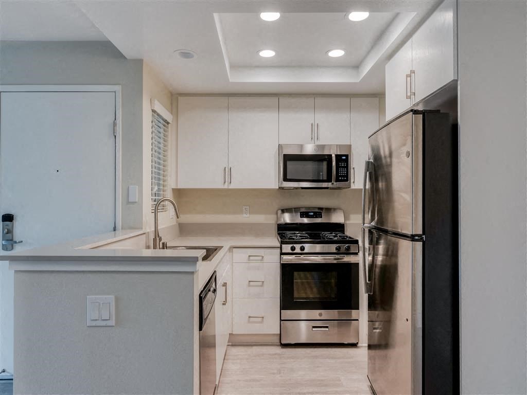 a kitchen with white cabinets and stainless steel appliances  at Laguna Gardens Apts., Laguna Niguel, CA, 92677