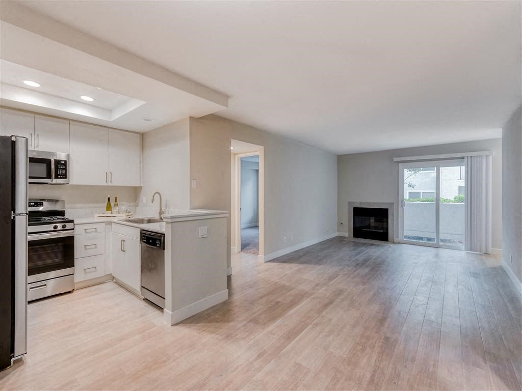 an empty kitchen and living room with a fireplace  at Laguna Gardens Apts., California, 92677