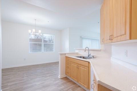 A kitchen with wooden cabinets and a white countertop at Cornerstone at Gale Ranch Apartments, San Ramon