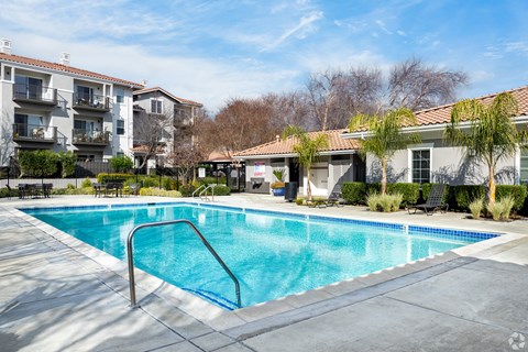 A swimming pool surrounded by a concrete patio and apartment buildings at Cornerstone at Gale Ranch Apartments, San Ramon, CA
