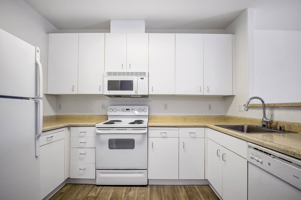 a kitchen with white cabinets and white appliances  at Cornerstone at Gale Ranch, California