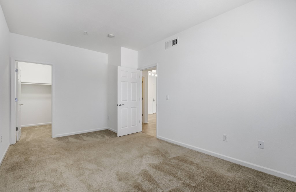 a bedroom with white walls and carpet  at Cornerstone at Gale Ranch, California