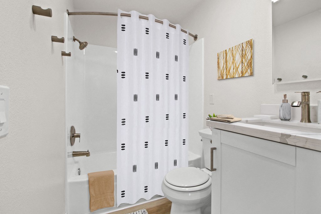 Bathroom with a white sink and toilet and a shower with a shower curtain  at Harvard Manor, Irvine, CA