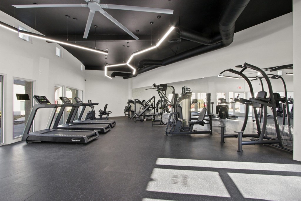 A gym with treadmills, elliptical machines, and other exercise equipment at Harvard Manor, Irvine, CA