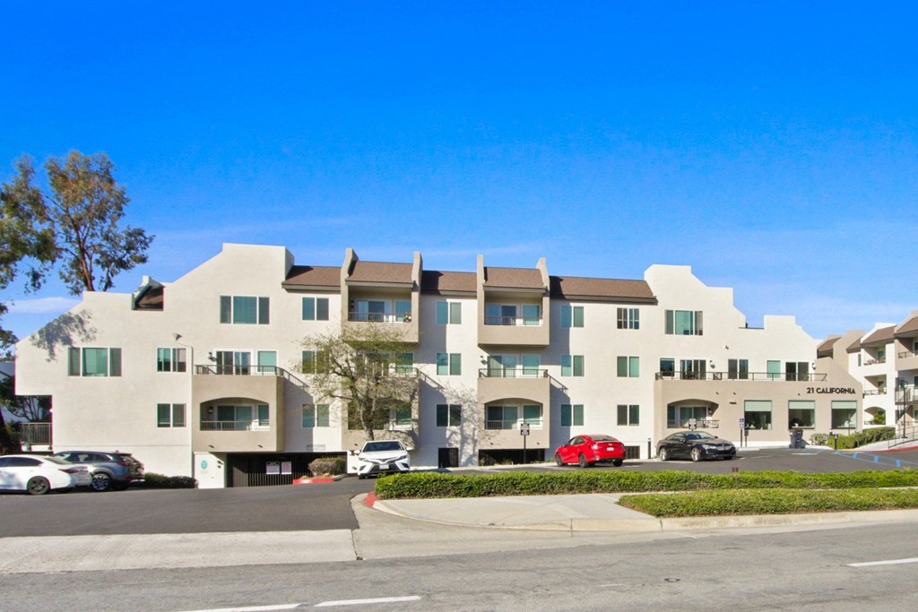 A large building with a parking lot in front at Harvard Manor, Irvine, CA 92612 