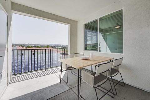 A balcony with a table and chairs overlooking a pool at Montecito at Carlsbad, Carlsbad, CA 92010