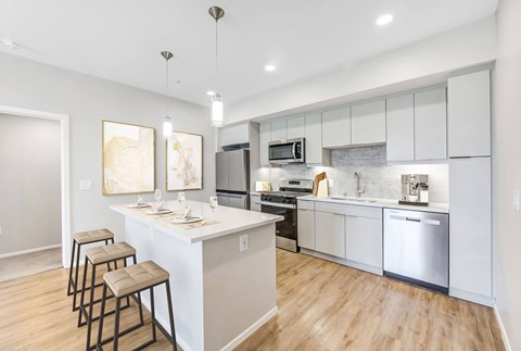 A modern kitchen with a bar area and stools at The Overlook Santa Clarita, CA 91350