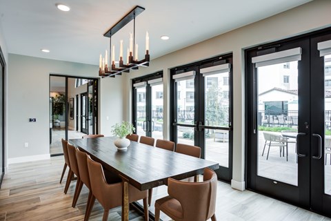 A modern dining room with a long table and chairs at Pradera Apartments, CA, 94582