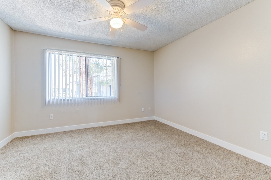 a bedroom with a ceiling fan and a window  at Redlands Park Apts, Redlands, 92373