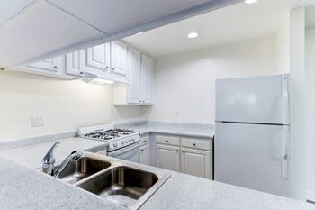 a kitchen with white cabinets and white appliances
