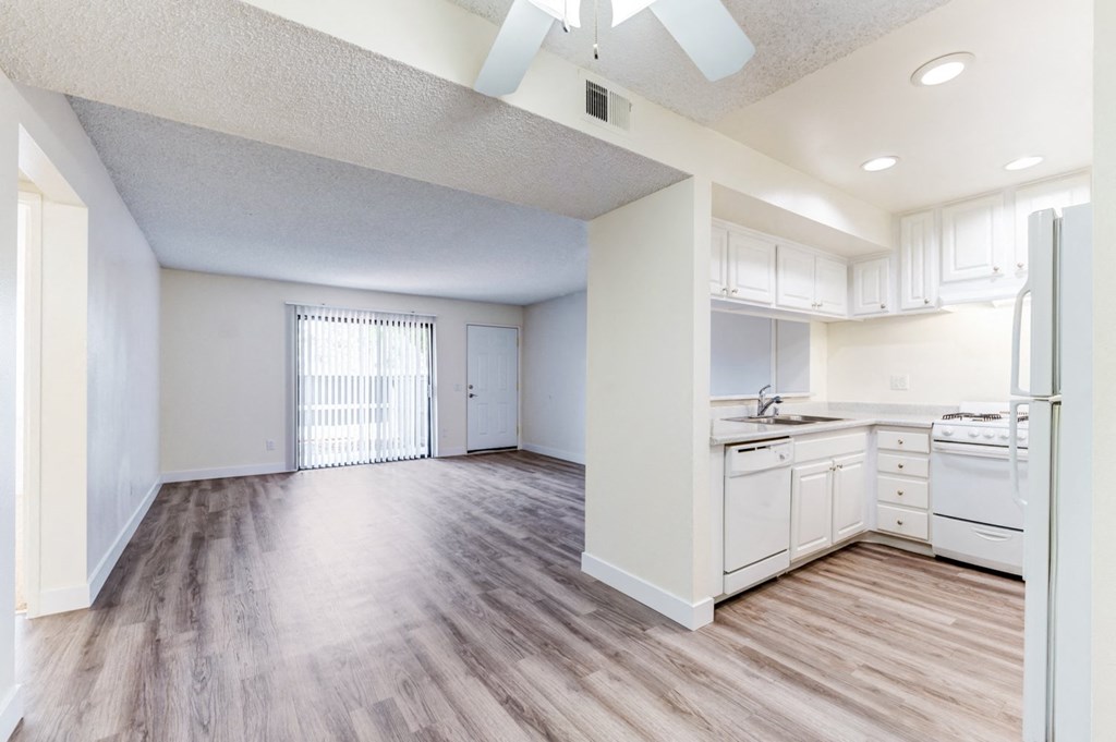 an empty kitchen and living room with a ceiling fan  at Redlands Park Apts, California, 92373