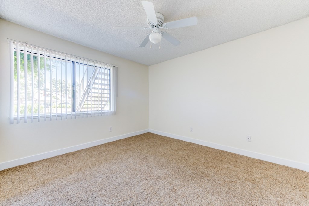a bedroom with a ceiling fan and a window  at Redlands Park Apts, Redlands, CA, 92373