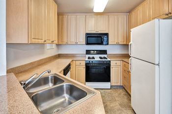 a kitchen with a sink stove refrigerator and microwave