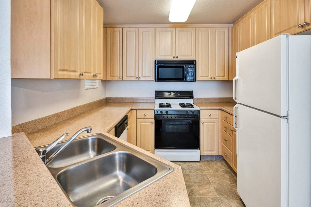 a kitchen with a sink stove refrigerator and microwave a kitchen with a sink stove refrigerator and microwave at Falcon Bridge at Gale Ranch, San Ramon, CA