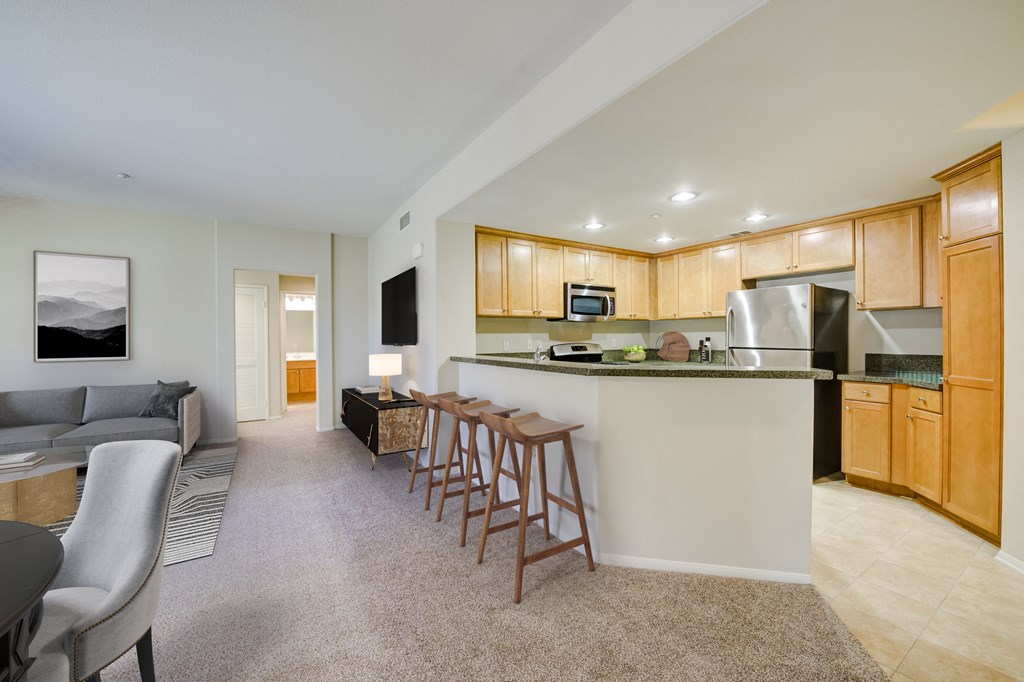 a kitchen and living room with wood cabinetry  at Sonoma at Porter Ranch, Porter Ranch, California