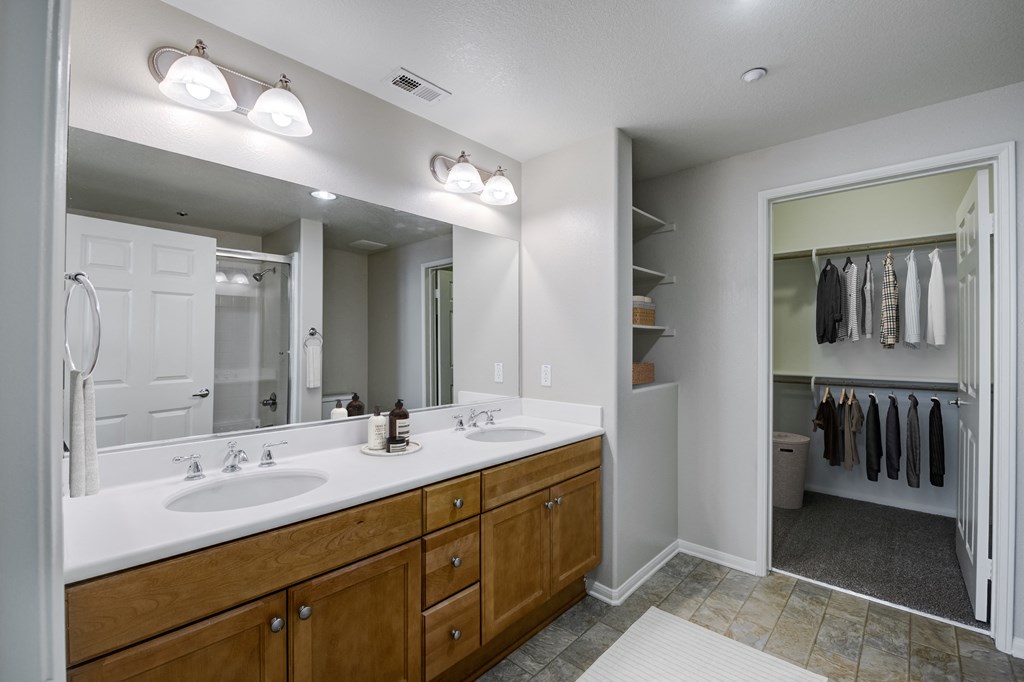 a bathroom with a large mirror and two sinks  at Sonoma at Porter Ranch, Porter Ranch, CA