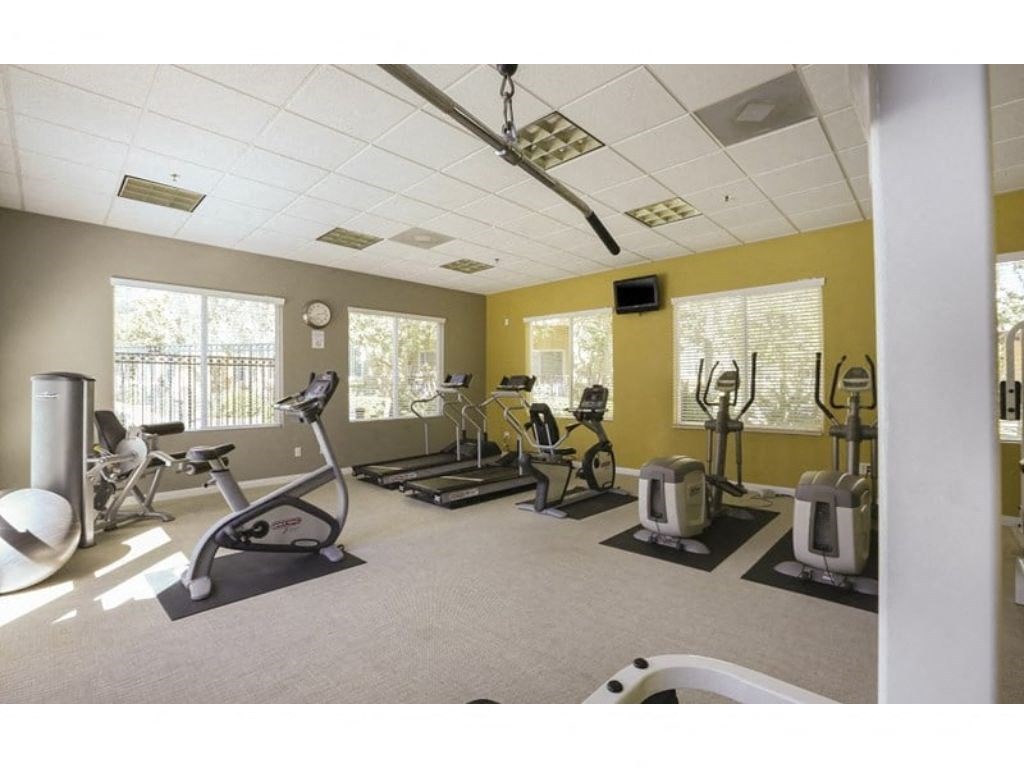 a room with a lot of exercise equipment in it  at Tesoro Senior Apartments, Porter Ranch