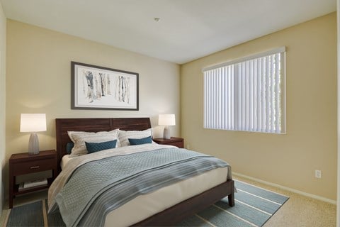 a bedroom with a large bed and two night stands with lamps  at Tesoro Senior Apartments, Porter Ranch, California