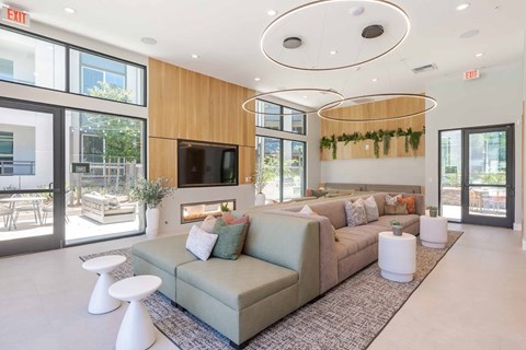 Clubhouse with greenery, grey couch and a television at The Overlook Santa Clarita, CA 91350