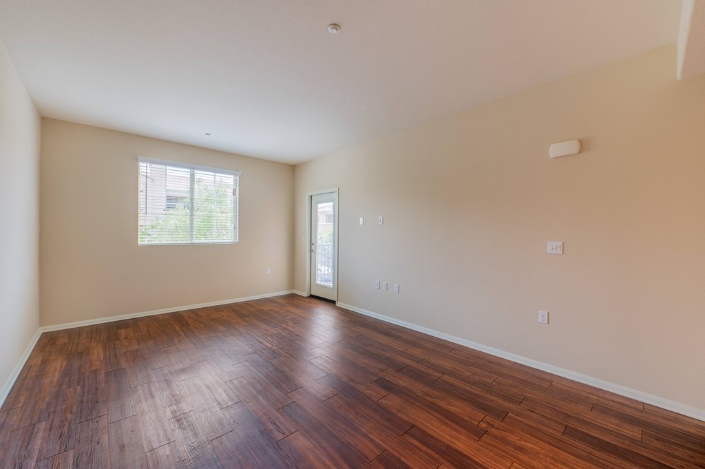 a bedroom with hardwood floors and a door leading to a balcony  at Ventana Senior Apartments, Northridge, CA