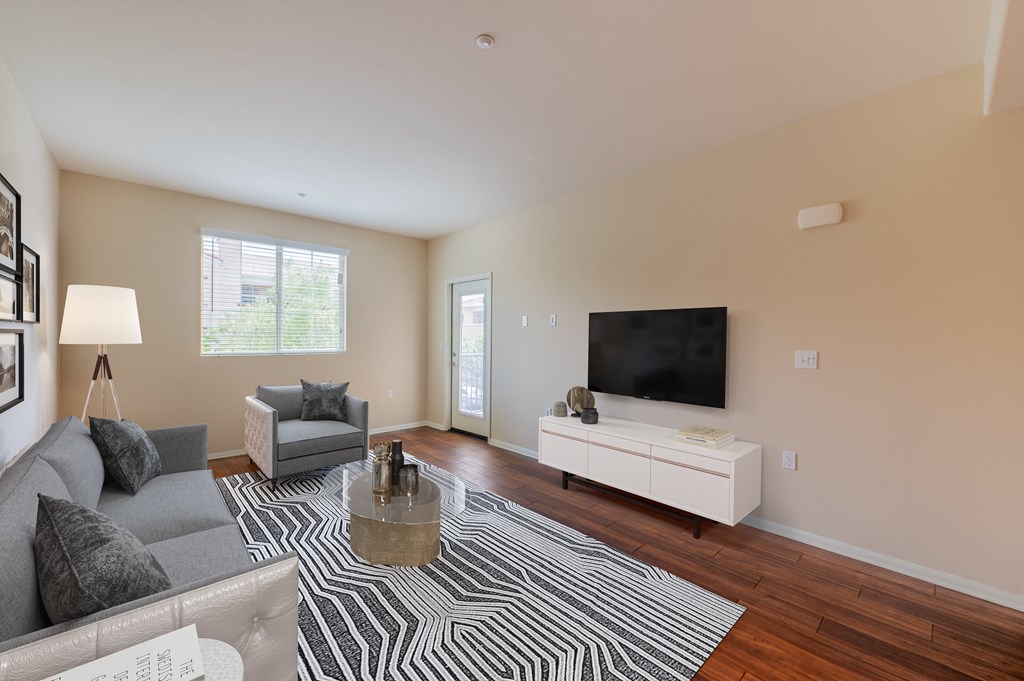 a living room with a couch and chair and a tv on the wall  at Ventana Senior Apartments, Northridge, CA, 91326