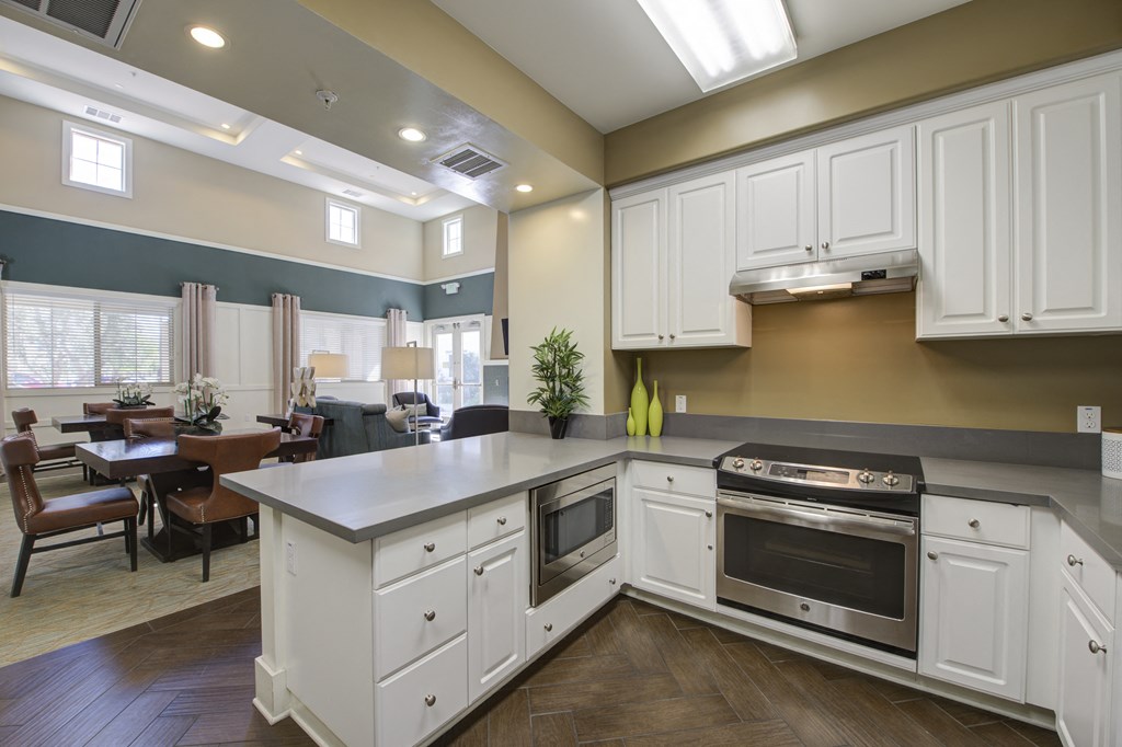 a kitchen with white cabinets and stainless steel appliances a kitchen with white cabinets and stainless steel appliances at Ventana Senior Apartments, California, 91326