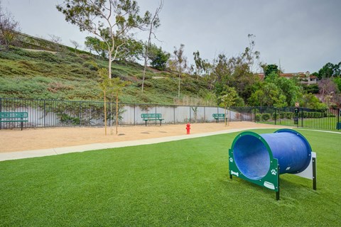a dog park with a large blue dog kennel and a red fire hydrant  at Laguna Gardens Apts., California, 92677
