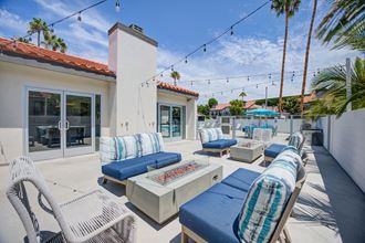 a patio with blue lounge chairs and a fire pit  at Laguna Gardens Apts., California - Photo Gallery 3