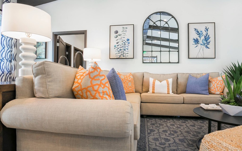 a living room with a tan couch and blue and orange pillows at Arroyo Villa Apartments, California, 91320