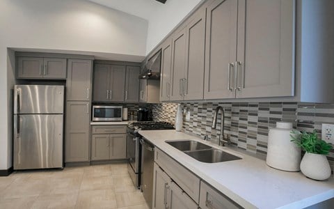 a kitchen with gray cabinets and a white counter top  at Arroyo Villa Apartments, Thousand Oaks, California