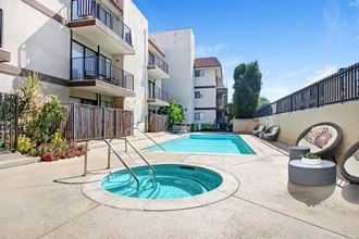 a swimming pool with a hot tub in front of an apartment building  at Sherway Villa, Reseda, 91335