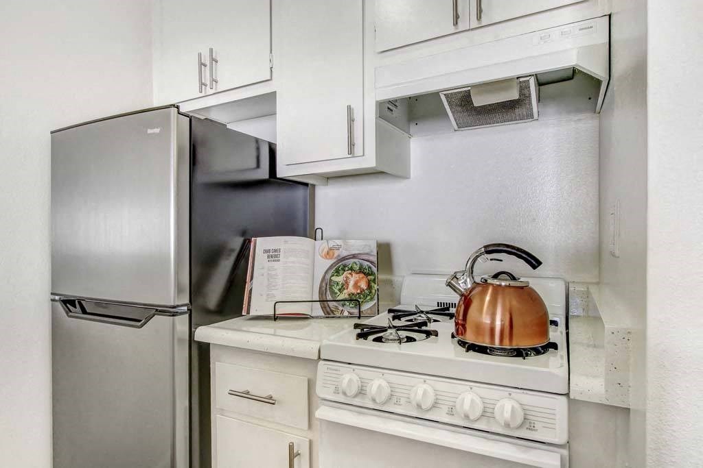 a kitchen with a stove top oven next to a refrigerator  at Sherway Villa, Reseda, California